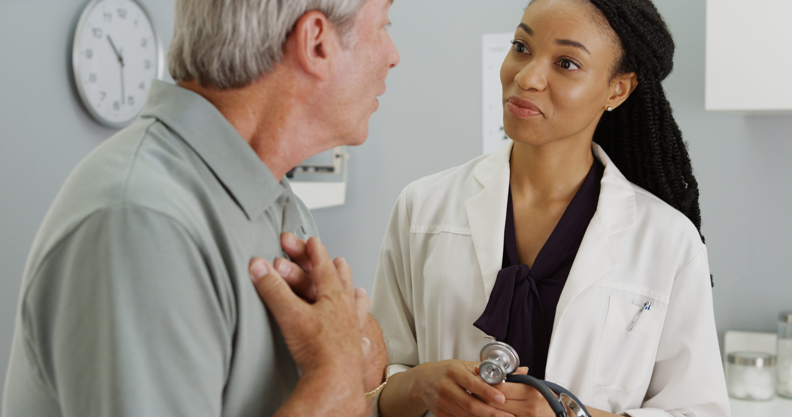 Black female doctor using excellent communications skills talking with older male patient | Vanguard Communications | Denver, Knoxville, TN, Jacksonville, FL