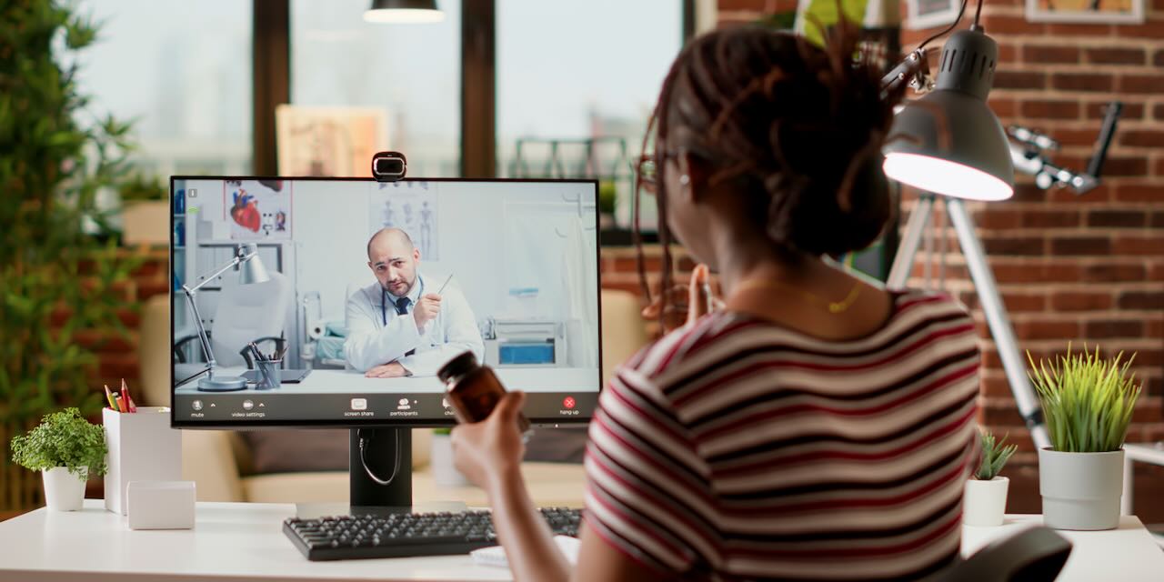 Black female patient engages with doctor on computer screen | Telehealth services boom | Vanguard Communications | Denver
