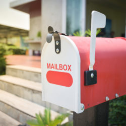 Photos of a white and red mailbox in front of a house signifying that the homeowner has mail in their box