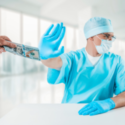 Male doctor in scrubs holds up his hand to refuse cash being handed to him | Article on Stark Law enforcement | Vanguard Communications | Denver