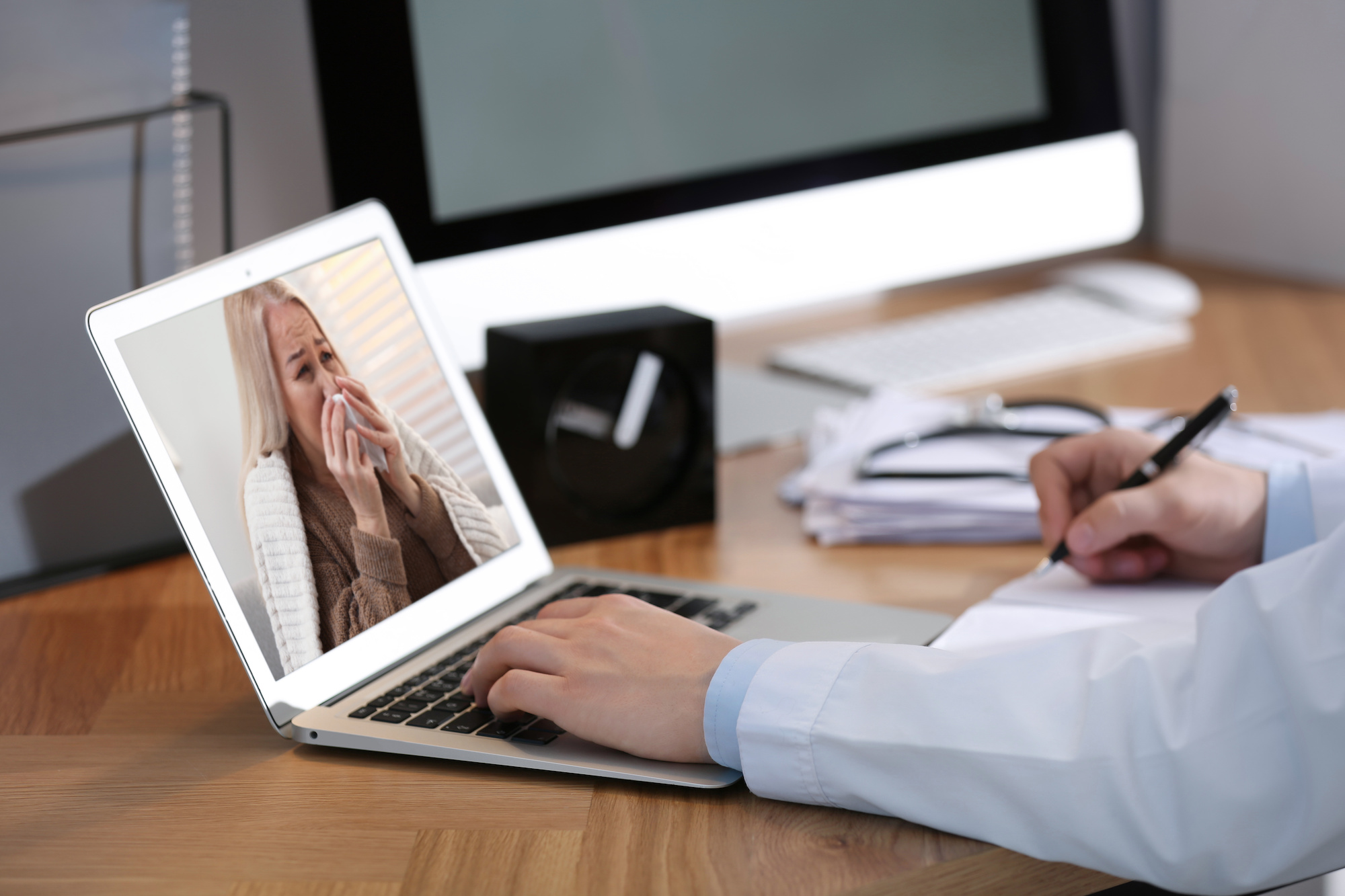 Doctor using proper netiquette for telehealth at laptop with a sick patient on the screen | Vanguard Communications | Denver, CO | San Jose, CA