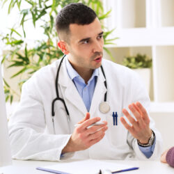 Physician seated speaking to man, enhancing the doctor patient relationship | Vanguard Communications | Denver, CO