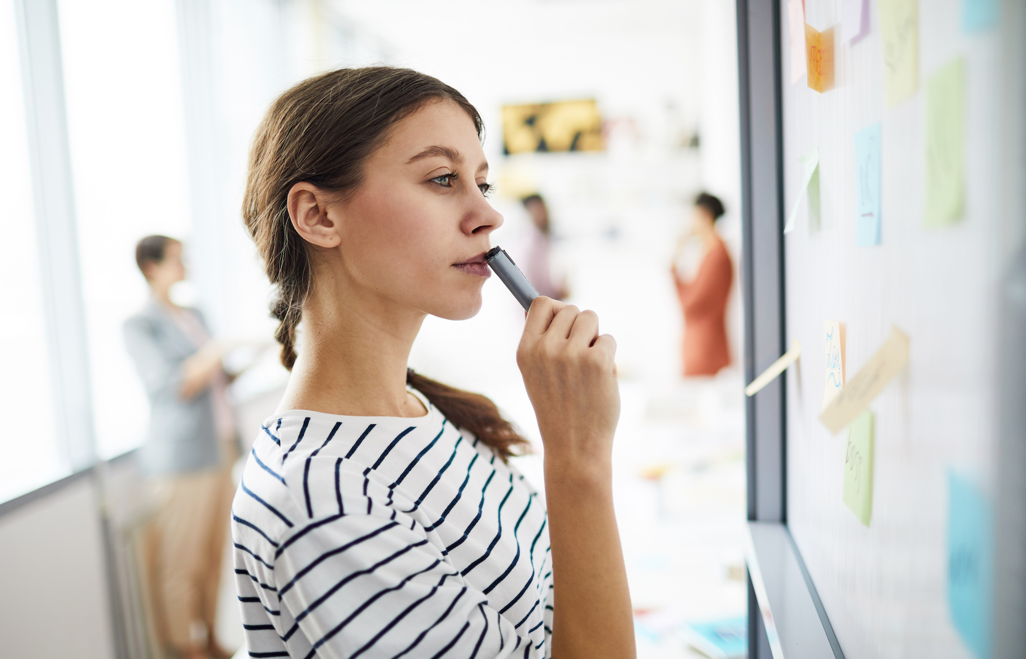 Woman looking at sticky notes for process problem solving | Vanguard Communications | Denver, CO | San Jose, CA | Jacksonville, FL