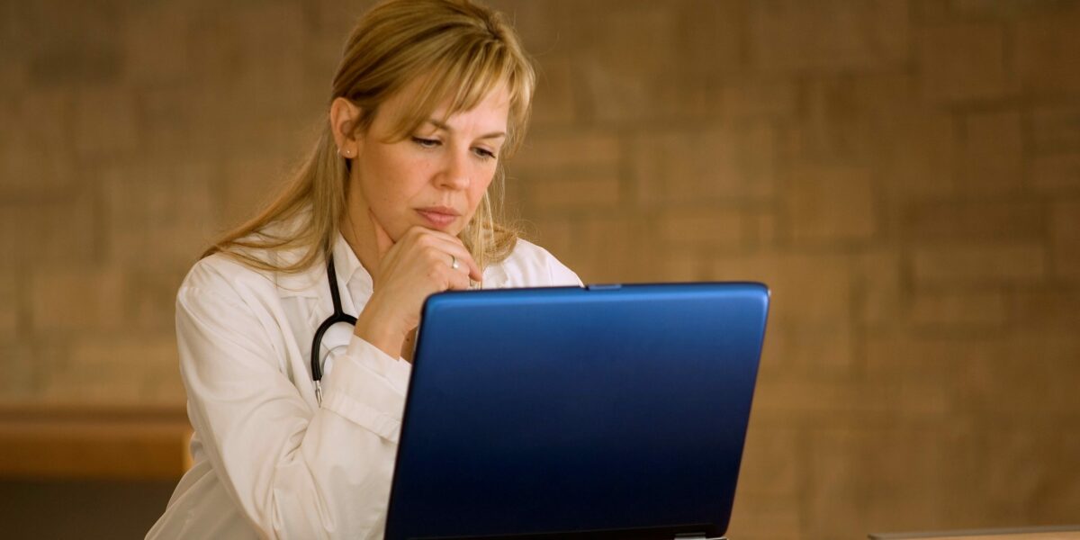 Doctor blogging | Vanguard Communications | Female doctor at laptop