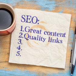 SEO (search engine optimization) tips (great content and quality links) written on napkin with a cup of coffee | Vanguard Communications | Denver, CO